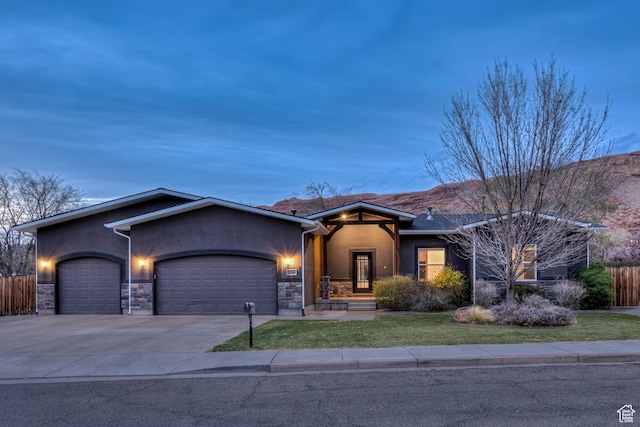 284 W Mcgill Blvd, Moab, UT 84532 - view of front of property featuring a garage, stucco siding, fence, and a front lawn