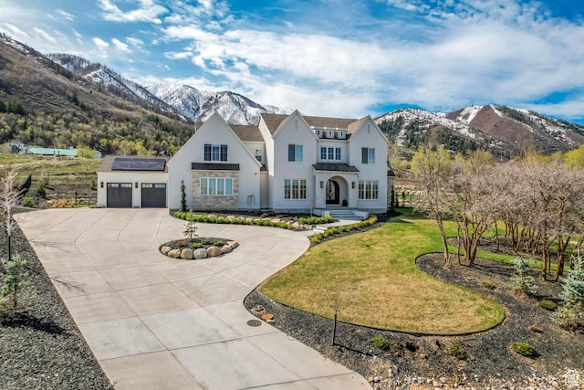 70 E Deer Meadow Ct, Woodland Hills, UT 84653 - view of front of house with roof mounted solar panels, curved driveway, stucco siding, a mountain view, and a garage