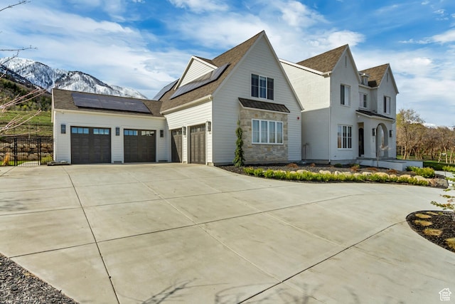 70 E Deer Meadow Ct, Woodland Hills, UT 84653 - view of property exterior featuring driveway, roof mounted solar panels, fence, a mountain view, and roof with shingles
