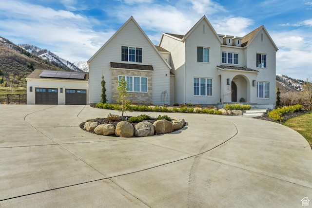 70 E Deer Meadow Ct, Woodland Hills, UT 84653 - view of front of property featuring roof mounted solar panels, curved driveway, stucco siding, stone siding, and a mountain view