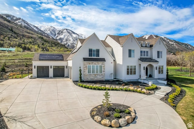 70 E Deer Meadow Ct, Woodland Hills, UT 84653 - view of front of property featuring roof mounted solar panels, concrete driveway, a standing seam roof, a mountain view, and a garage