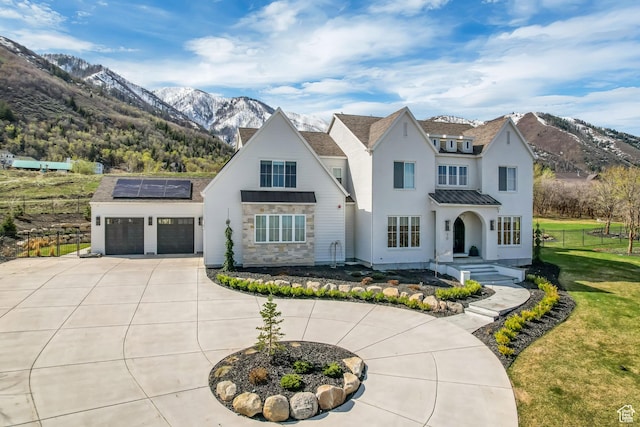 70 E Deer Meadow Ct, Woodland Hills, UT 84653 - view of front of home featuring curved driveway, roof mounted solar panels, fence, and a mountain view