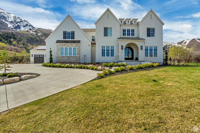 70 E Deer Meadow Ct, Woodland Hills, UT 84653 - view of front of house with a front lawn, a mountain view, fence, concrete driveway, and stucco siding