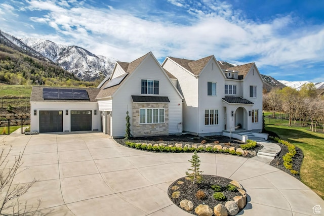 70 E Deer Meadow Ct, Woodland Hills, UT 84653 - view of front facade featuring concrete driveway, an attached garage, a mountain view, solar panels, and a standing seam roof