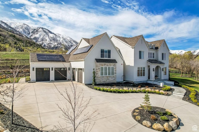 70 E Deer Meadow Ct, Woodland Hills, UT 84653 - view of front of property featuring roof mounted solar panels, driveway, a garage, and a mountain view