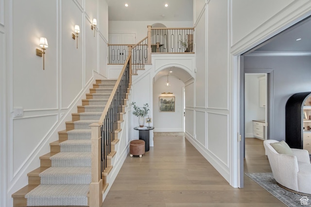 70 E Deer Meadow Ct, Woodland Hills, UT 84653 - entryway featuring arched walkways, light wood-style floors, stairway, and a decorative wall