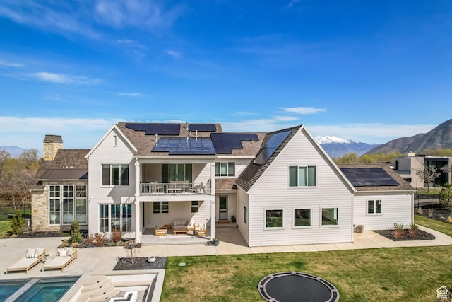 70 E Deer Meadow Ct, Woodland Hills, UT 84653 - back of house with a balcony, solar panels, a patio area, an outdoor living space with a fire pit, and a mountain view