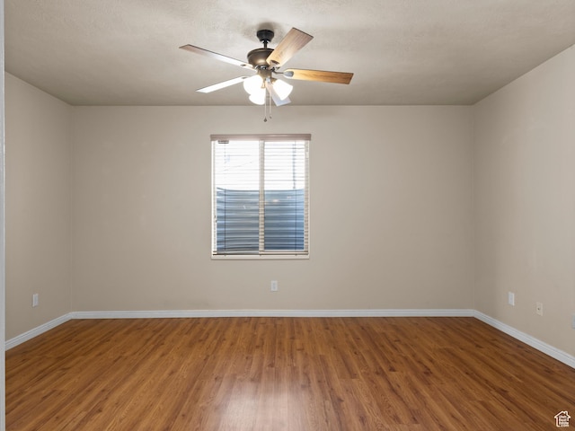 unfurnished room with ceiling fan, baseboards, and wood finished floors
