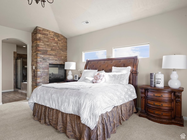 bedroom featuring visible vents, baseboards, arched walkways, carpet floors, and lofted ceiling