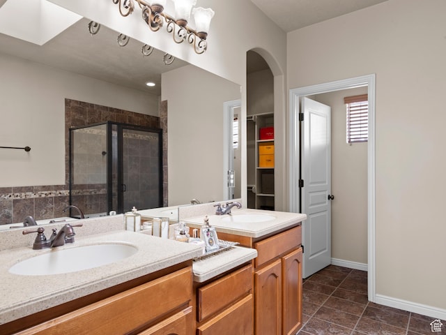 bathroom featuring a shower stall, tile patterned floors, double vanity, and a sink