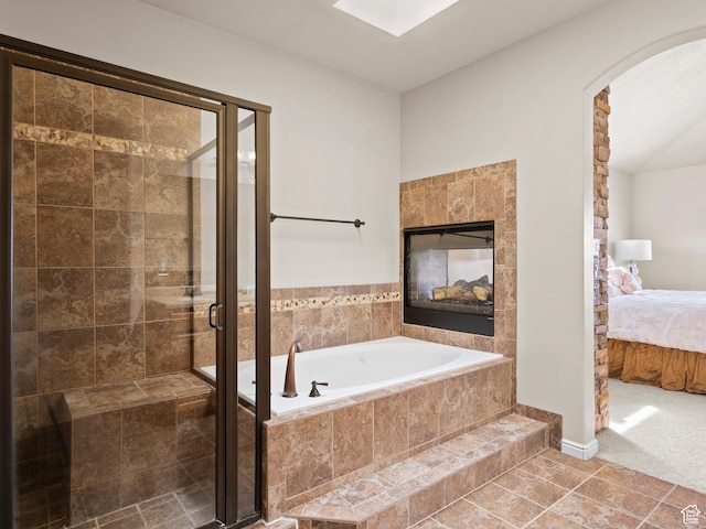 ensuite bathroom with a shower stall, a bath, ensuite bathroom, and a fireplace