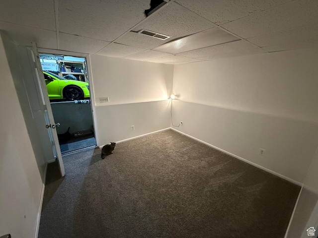 below grade area with carpet flooring, baseboards, a drop ceiling, and visible vents