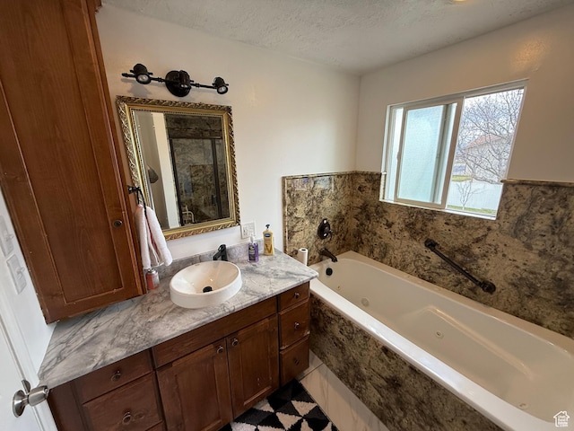 bathroom featuring a shower stall, a jetted tub, vanity, and a textured ceiling
