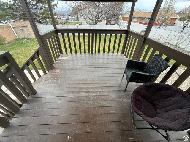 wooden deck with a yard and fence