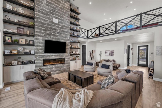 444 S 1530 W, Hurricane, UT 84737 - living room featuring a fireplace, light wood-type flooring, a towering ceiling, recessed lighting, and baseboards