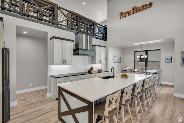 444 S 1530 W, Hurricane, UT 84737 - kitchen featuring wall chimney exhaust hood, light wood-style flooring, tasteful backsplash, black appliances, and a sink