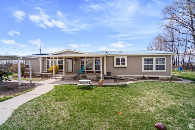 rear view of property featuring a yard and metal roof