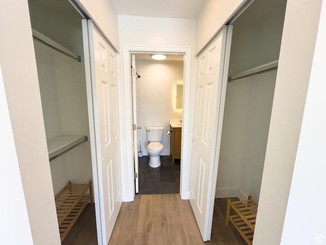 bathroom with toilet, wood finished floors, and vanity