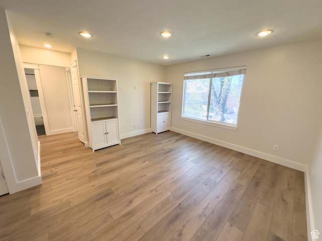 unfurnished bedroom featuring light wood-style flooring, baseboards, and recessed lighting