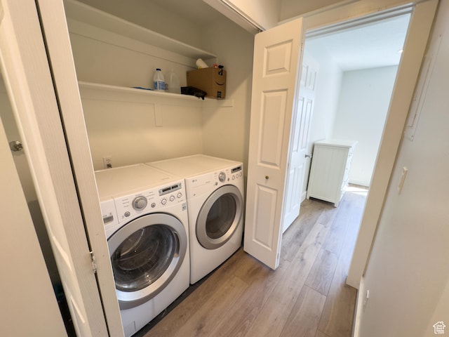 washroom featuring laundry area, washing machine and clothes dryer, and light wood-type flooring