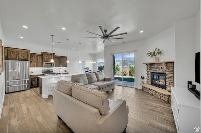 3086 W 570 N, Hurricane, UT 84737 - living room with light wood finished floors, a fireplace, a ceiling fan, and recessed lighting