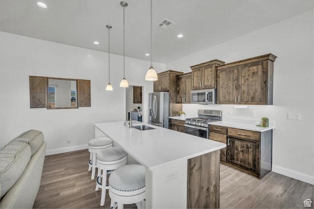 3086 W 570 N, Hurricane, UT 84737 - kitchen with visible vents, appliances with stainless steel finishes, wood finished floors, a sink, and a breakfast bar area