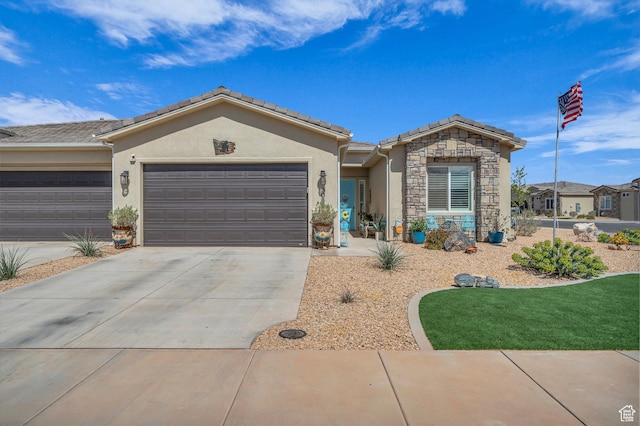 ranch-style home with stone siding, a garage, a tile roof, concrete driveway, and stucco siding