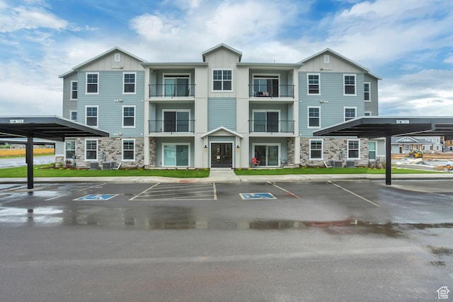 view of property featuring covered and uncovered parking