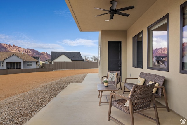 view of patio / terrace with a mountain view, fence, and a ceiling fan