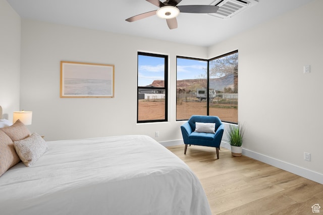 bedroom with light wood-style flooring, ceiling fan, baseboards, and visible vents