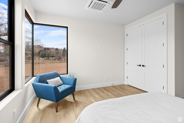 bedroom with visible vents, baseboards, a closet, a ceiling fan, and wood finished floors