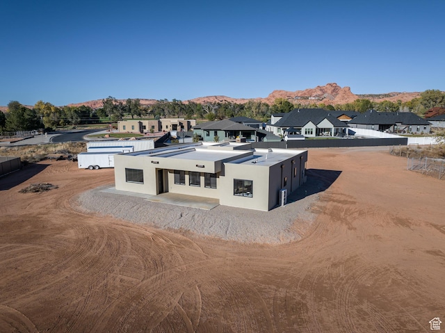 exterior space featuring a residential view, stucco siding, and a mountain view