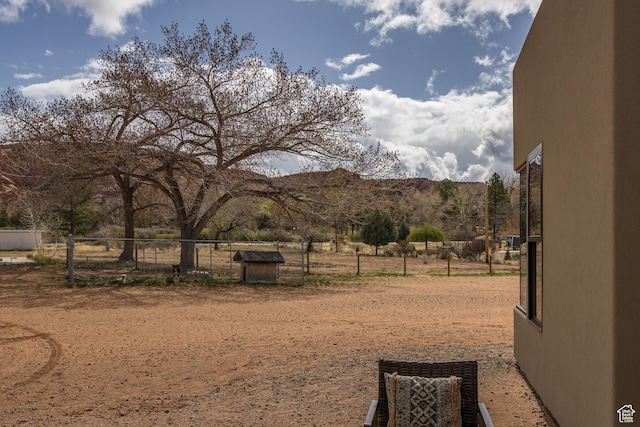 view of yard featuring a mountain view and fence
