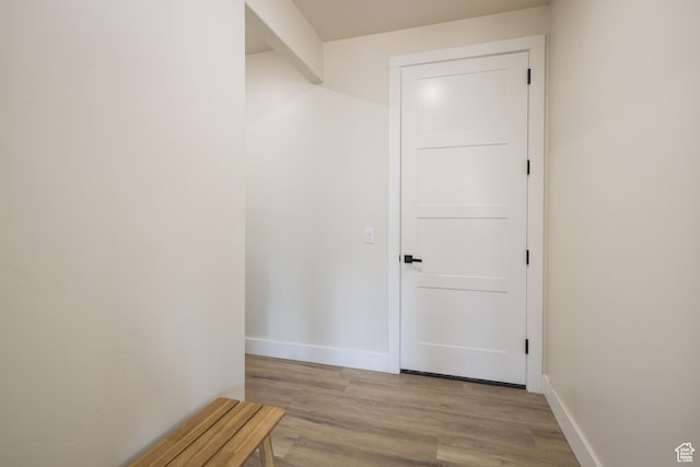 hall featuring wood finished floors and baseboards
