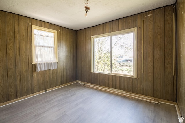 unfurnished room featuring baseboards and wood finished floors