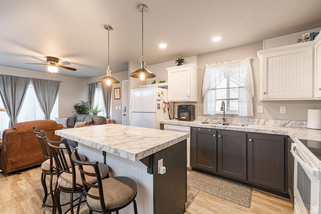 1150 W Red Hills Pkwy Unit 57, Washington, UT 84780 - kitchen featuring light countertops, a sink, white appliances, and a kitchen breakfast bar