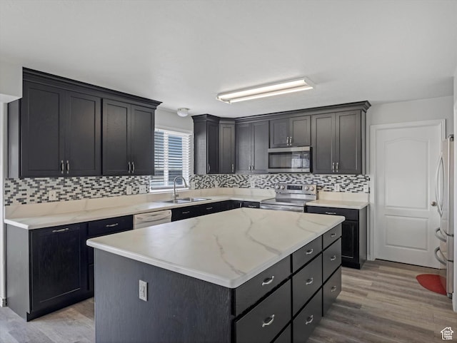 4572 W Bingham Park Dr S, West Jordan, UT 84088 - kitchen with tasteful backsplash, a kitchen island, light wood-style floors, appliances with stainless steel finishes, and a sink