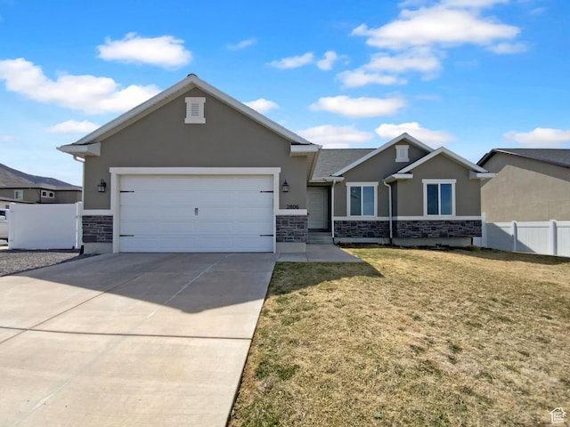 view of front of house featuring a front yard, a garage, fence, concrete driveway, and stucco siding