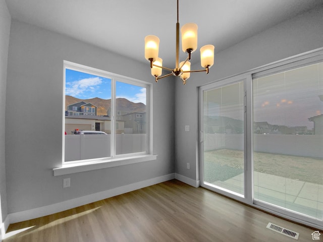 2806 E Crimson Ct, Eagle Mountain, UT 84005 - unfurnished dining area featuring a chandelier, wood finished floors, baseboards, and visible vents