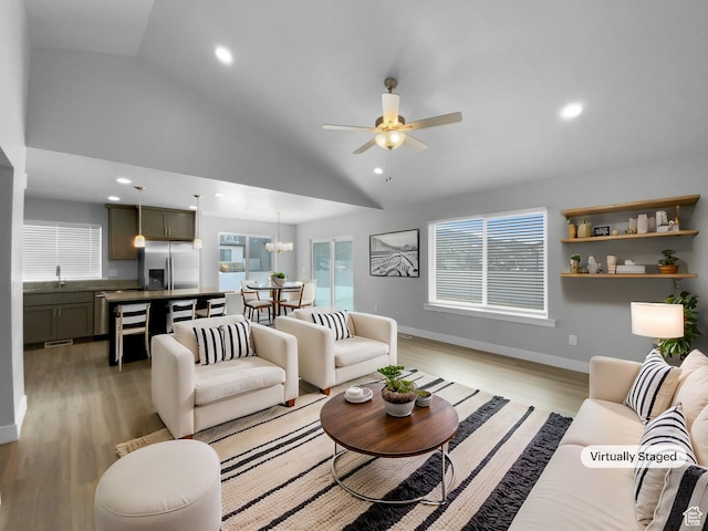 2806 E Crimson Ct, Eagle Mountain, UT 84005 - living area featuring baseboards, light wood finished floors, recessed lighting, ceiling fan with notable chandelier, and high vaulted ceiling