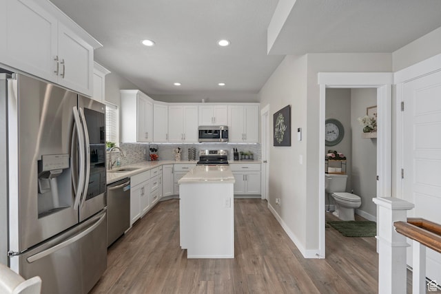 7091 N Oquirrh Ranch Pkwy, Eagle Mountain, UT 84005 - kitchen with white cabinets, a sink, light countertops, appliances with stainless steel finishes, and backsplash