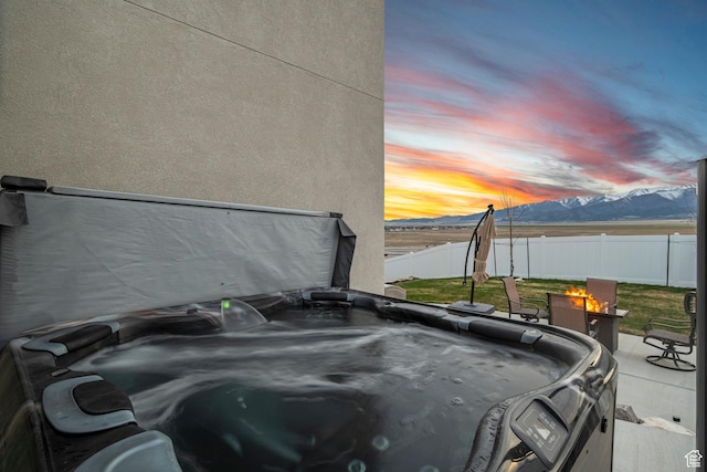 7091 N Oquirrh Ranch Pkwy, Eagle Mountain, UT 84005 - exterior space with a mountain view, a fenced backyard, a patio area, and a hot tub