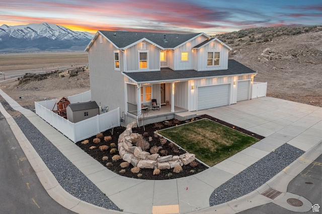 7091 N Oquirrh Ranch Pkwy, Eagle Mountain, UT 84005 - modern farmhouse style home with a mountain view, a porch, board and batten siding, fence, and concrete driveway
