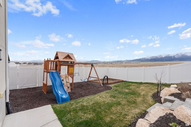 7091 N Oquirrh Ranch Pkwy, Eagle Mountain, UT 84005 - view of playground with a fenced backyard, a mountain view, and a lawn