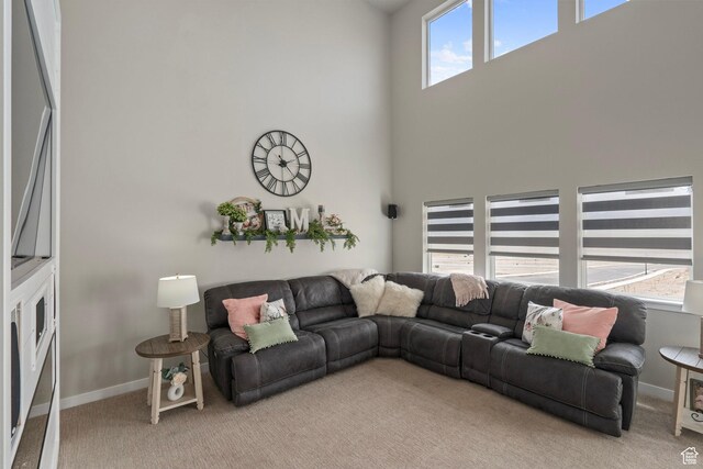7091 N Oquirrh Ranch Pkwy, Eagle Mountain, UT 84005 - living room with light carpet, a towering ceiling, and baseboards