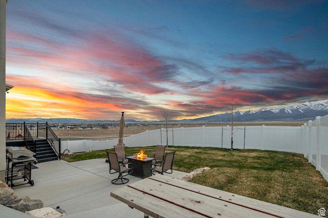 7091 N Oquirrh Ranch Pkwy, Eagle Mountain, UT 84005 - view of patio with a fenced backyard, an outdoor fire pit, grilling area, a deck with mountain view, and stairs