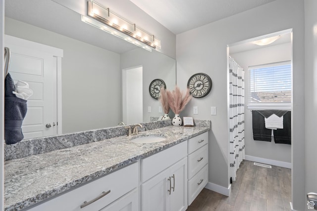 7091 N Oquirrh Ranch Pkwy, Eagle Mountain, UT 84005 - bathroom with wood finished floors, vanity, baseboards, and visible vents