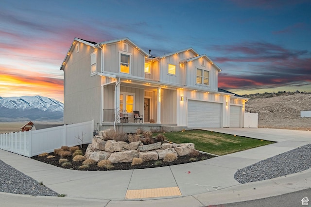 7091 N Oquirrh Ranch Pkwy, Eagle Mountain, UT 84005 - view of front of property with board and batten siding, a porch, fence, an attached garage, and concrete driveway