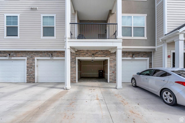 108 W Seasons Dr, Vineyard, UT 84059 - view of front facade with a garage, a balcony, driveway, and stone siding