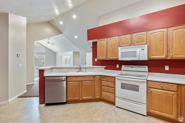 kitchen featuring white appliances, a peninsula, light countertops, a sink, and lofted ceiling